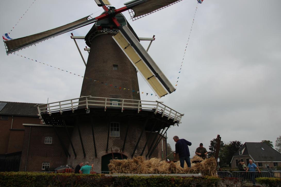 De molen met de dorsmachine op de voorgrond
